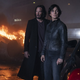 Neo and Trinity standing in front of a burning car.